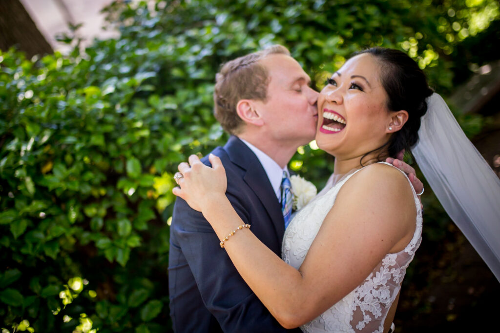 A groom gives his new wife a kiss on the cheek